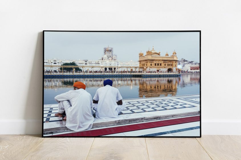 Print of a scene of the Golden Temple at sunset with two Sikhs in the foreground, in Amritsar